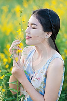 Asian woman smelling flowers.