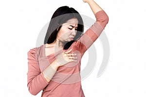 Asian woman smelling her smelly and sweating armpit