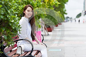 Asian woman smile sitting bench summer city