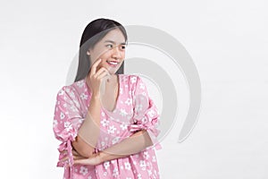 Asian woman smiles with fresh face and wears pink dress while touch her face.
