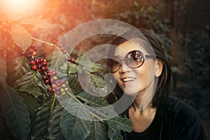 Asian woman smiling face happiness emotion near raw coffee seed on tree branch