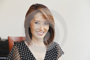 Asian woman smiling at her desk