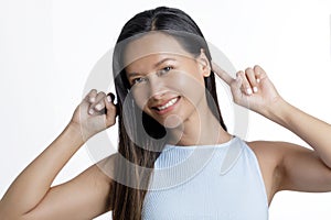 Asian Woman smiling and pointing at her Ears white background