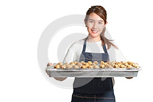 Asian woman smiling wear white t-shirt with apron holding tray with cookies isolate on white background, With clipping path