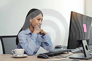 Asian woman software developers sitting in front of computers looking at computer codes on the screen