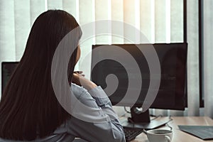 Asian woman software developers sitting in front of computers looking at computer codes on the screen