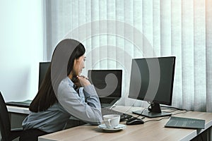 Asian woman software developers sitting in front of computers looking at computer codes on the screen