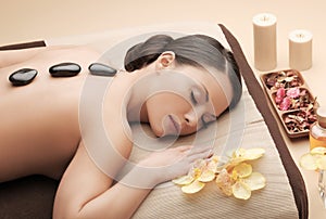 Asian woman in spa with hot stones