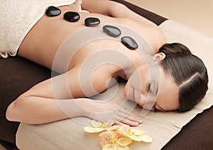 Asian woman in spa with hot stones
