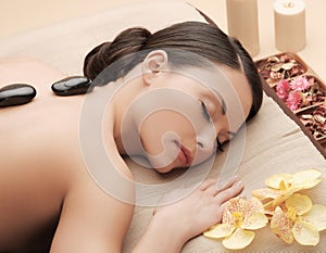 Asian woman in spa with hot stones