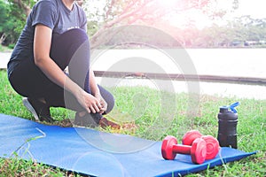 Asian woman in sport clothing tying shoes getting ready for exercise in park, Workout and Healthy lifestyle