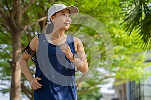 Asian woman sportswoman fit body wearing sport wear and smile while jogging in the garden