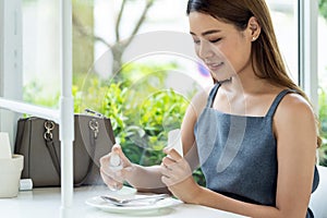 Asian woman spraying alocohol on restauranr dishware