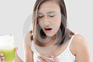 Asian woman is squeamish from the juice against gray background.