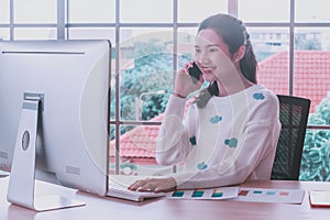 Asian woman staff working,smartphone and pc computer,happy smiling at home office,remote presenting marketing plan report online
