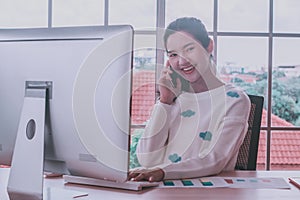 Asian woman staff working,smartphone and pc computer,happy smiling at home office,remote presenting marketing plan report online