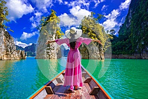 Asian woman standing on boat in Ratchaprapha dam Khao sok national park at Suratthani,Thailand