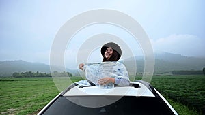 Asian woman standing out of car sunroof. Relaxing and freedom with spring time. Young tourist travel alone in Thailand on summer