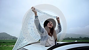 Asian woman standing out of car sunroof. Relaxing and freedom with spring time. Young tourist travel alone in Thailand on summer