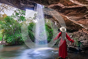 Asian woman standing on the rock at Saeng Chan Waterfall Long Ru Waterfall, Ubon Ratchathani Province, Thailand.The stone holes