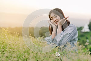 Asian woman Standing smiling in the fields of green grass in the morning sun With a happy face