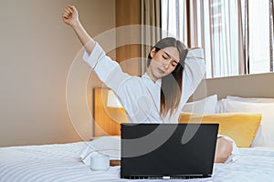 Asian woman stretching on the bed in the Morning