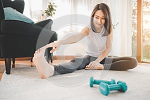 Asian woman stretching her leg  at home