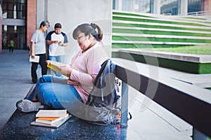 Asian woman student, sitting and reading a book To review the lesson