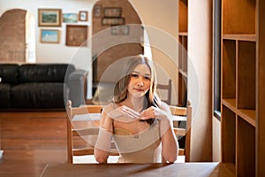 asian woman in stylish dress s sits on a chair posing indoors at the home office.