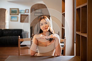 asian woman in stylish dress s sits on a chair posing indoors at the home office.