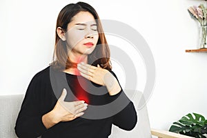 Asian woman suffering from acid reflux or gastroesophageal reflux disease GERD feeling uncomfortable and burning chest photo