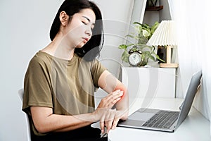 Asian Woman Suffering with Arm Pain from Laptop Usage, Overuse Injury, Mouse Arm Syndrome