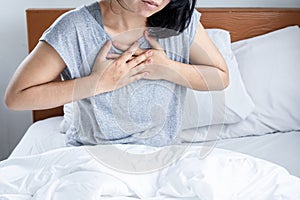 Asian woman suffering from chest pain, difficult to breathe , panic attack or heartburn