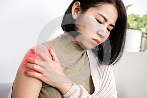 Asian woman suffering from frozen shoulder with pain and stiffness