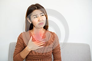 Asian woman suffering from gastroesophageal, acid reflux disease or heartburn photo