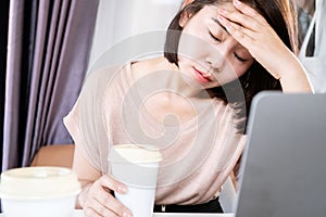 Asian woman suffering from headaches after drinking too much coffee