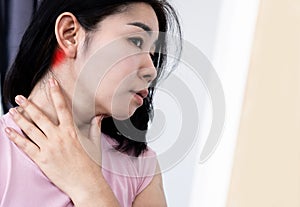 closeup Asian woman suffering from lymphadenitis, lymph node inflammation and feeling pain , swollen behide the ear photo