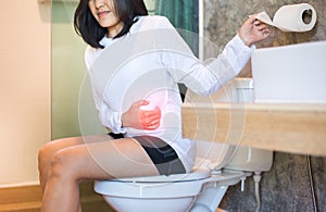 Asijský žena hemoroidy nebo zácpa v záchod žena na záchod v ráno 