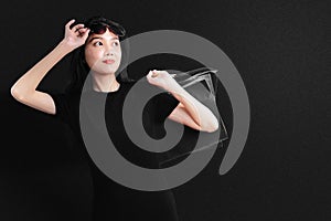 Asian woman with sunglasses carrying a shopping bag with a black background