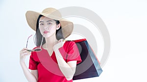 Asian woman with sunglasses and hat are shopping in the summer she is using a credit card and enjoys shopping. Nice charming girl