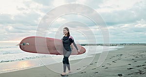 Asian woman, surfboard and walk by ocean, smile and ready for workout, training or wellness in morning. Person, surfer