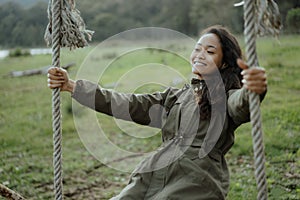 Asian woman swing her self in a countryside