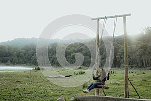 Asian woman swing her self in a countryside