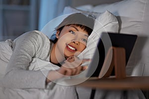 asian woman with tablet pc in bed at home at night