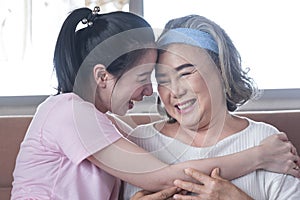 Asian woman take care and warn hug mother, she is very happy and smile in living room