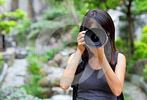 Asian woman taking photo with backpack