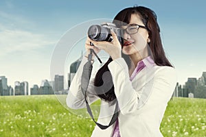 Asian woman taking picture using digital camera