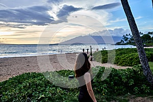 Asian woman taking a selfy at a beach near a resort in Maui of Hawaii, USA