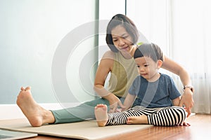 Asian woman teaching little boy doing yoga