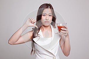 Asian woman thumbs down hate tomato juice.